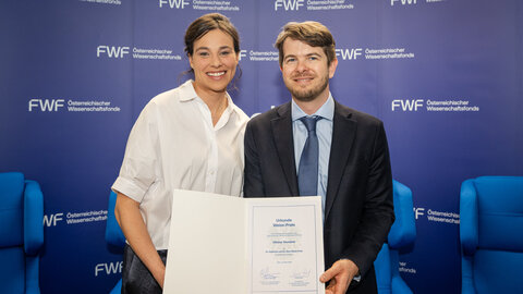 Elisabeth Gasteiger und Ottokar Stundner zeigen die Urkunde des Weiss-Preises