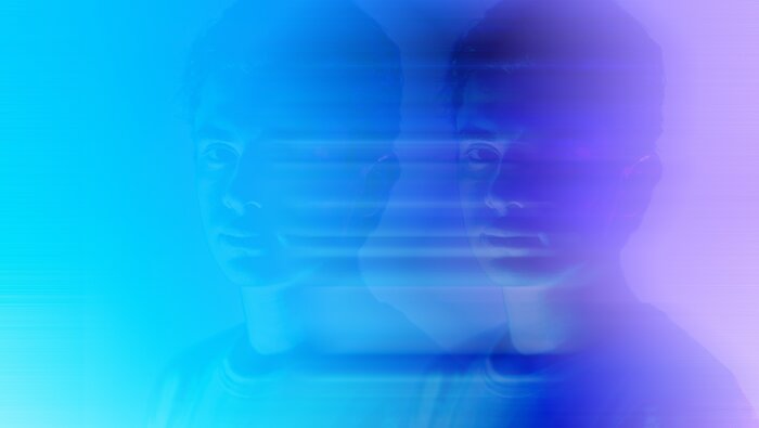 Zwei unscharfe Gesichter, eines als Schatten, eine jungen Mannes in lila-blauen Farben