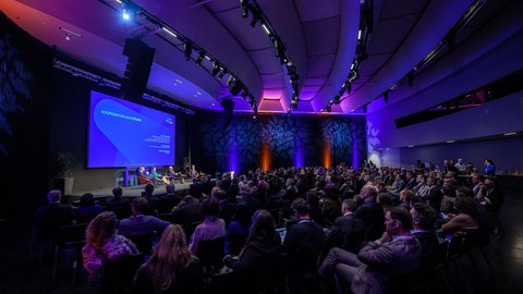 Blick von der Seite ins Publikum und auf die Bühne des Think Beyond Summit 2026