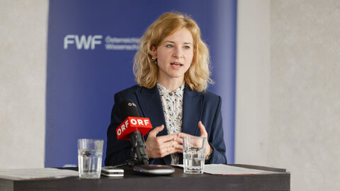Wissenschaftsministerin Eva-Maria Holzleitner vor blauer FWF-Logowand