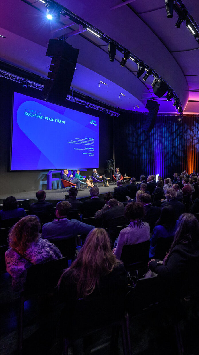 Ansicht von hinten links aufs Publikum und auf die Leinwand