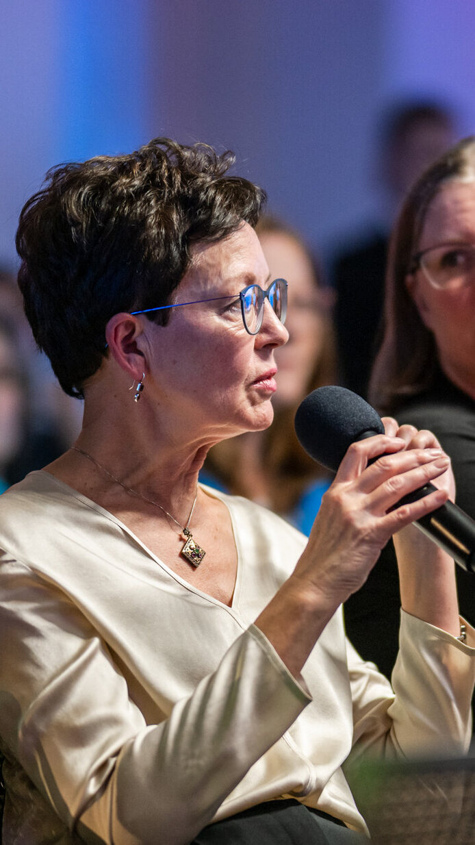 Eine Teilnehmerin stellt eine Publikumsfrage