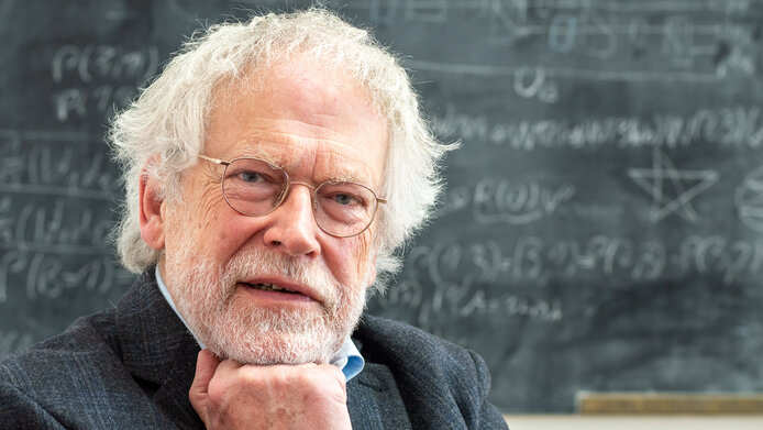 Porträt von Anton Zeilinger, nachdenklich vor einer Tafel