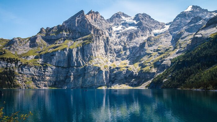 Ein gro&szlig;er dunkelblauer See umrahmt von Bergen