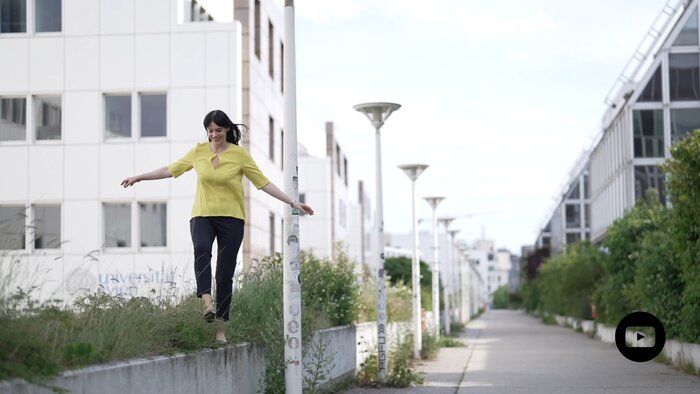 Nicole Amberg balanciert mit ausgebreiteten Armen auf einer Mauer