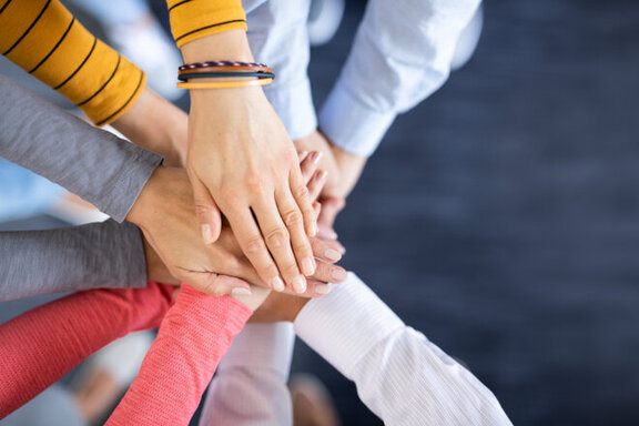 Several hands touching each other