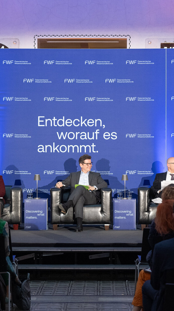 Matthias Weber, Ruth Breu, Christoph Neumayer, Gabriel Felbermayr und FWF-Präsident Christof Gattringer auf der Bühne. Teilnehmer:innen im Vordergrund.