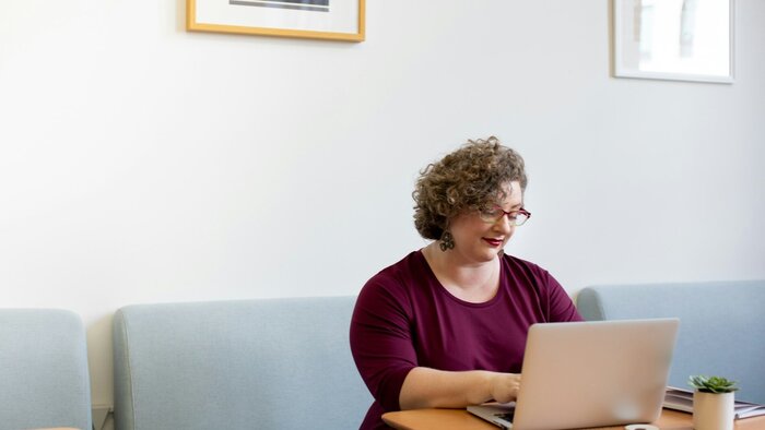 Arbeitende Frau mit Laptop am Tisch