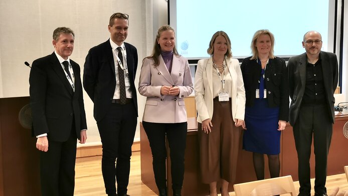 Gruppenfoto von fünf Personen, die nebeneinander vor einem Pult stehen. V. l. n. r.: Christopher Smith (UKRI), Christof Gattringer (FWF), Mari Sundli Tveit (RCN), Milica Đurić-Jovičić (SFRS), Katarina Bjelke (VR), Javier Moreno Fuentes (CSIC)