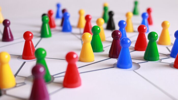 Viele bunte Spielfiguren auf einem weißen Spielfeld