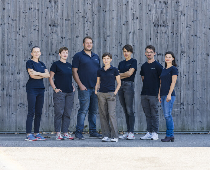 Birgit Mitter und ihr Team vor einer modernen Holzfassade