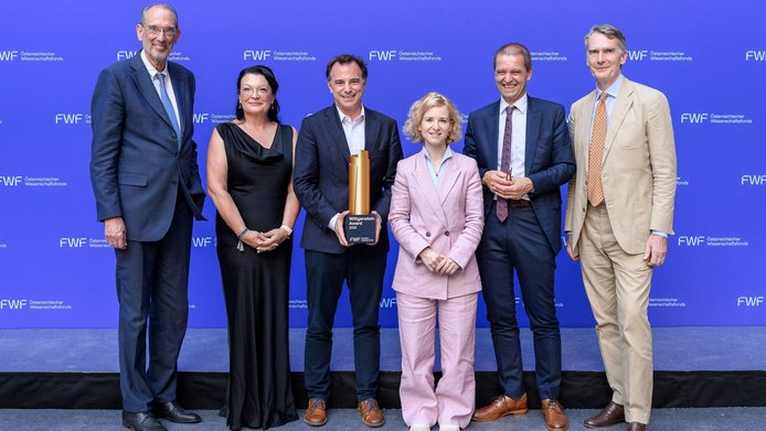 ÖAW-Präsident Heinz Faßmann, FWF-Vizepräsidentin Ursula Jakubek, Preisträger Markus Aspelmeyer, Wissenschaftsministerin Eva-Maria Holzleitner, FWF-Präsident Christof Gattringer und Uni-Wien-Rektor Sebastian Schütze vor der blauen FWF-Logowand