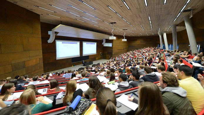 Many students in a large university lecture hall
