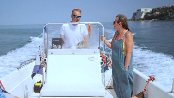 Monika Bright auf einem wei&szlig;en Motorboot schaut auf den das Boot Steuernden