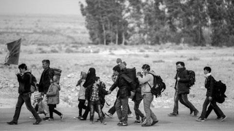 Ein Gruppe Erwachsene und Kinder auf der Flucht.