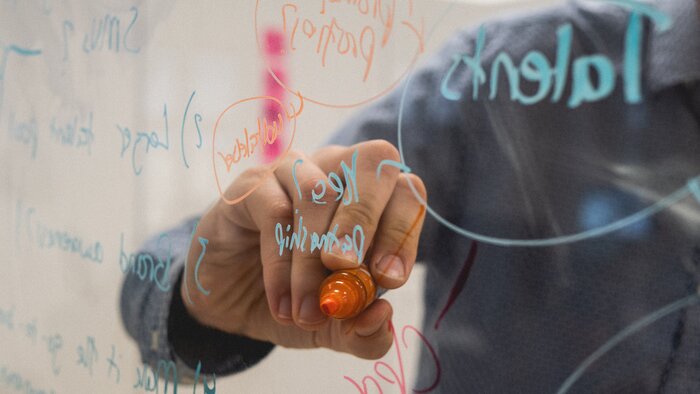 Person schreibt auf Flipchart