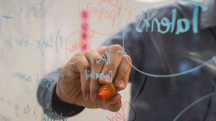Person schreibt auf Flipchart