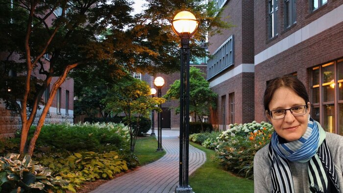 Forscherin mit alten Backsteingebäuden des St. George Campus Toronto im Hintergrund