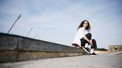 Drei junge Männer sitzen auf einer Steinstiege im Park 