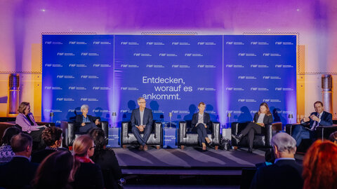 Hannelore Veit, Manuela Baccarini, Christian Pohl, Barbara Weitgruber, Mari Sundli Tveit und FWF-Präsident Christof Gattringer auf der Bühne. Teilnehmer:innen im Vordergrund. 