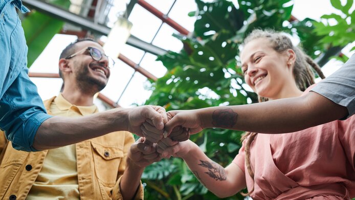 Several adults fist bump each other