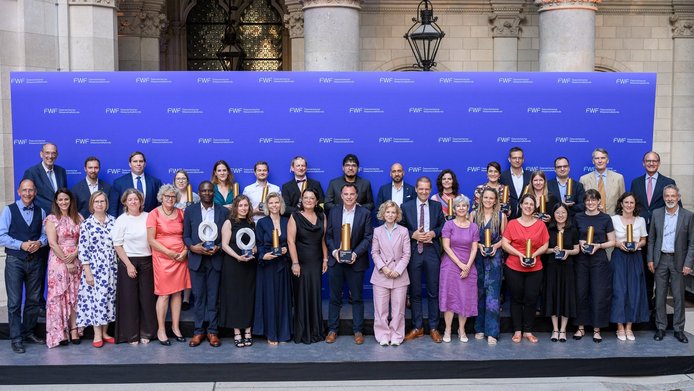 Der FWF-Wittgenstein-Preisträger Markus Aspelmeyer im Kreise aller ausgezeichneten Forschenden der Austrian Science Awards 2026 im Rathaus vor der FWF-Logowand
