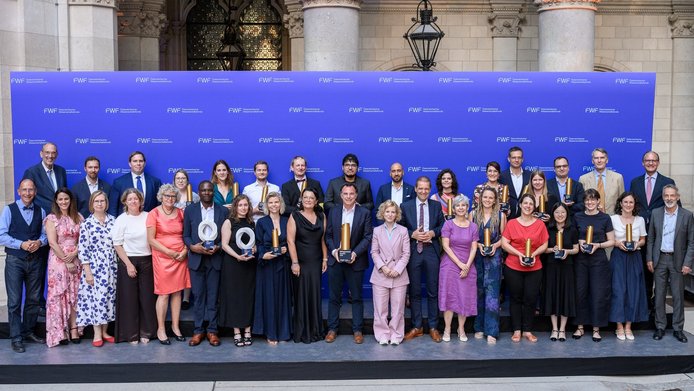 Der FWF-Wittgenstein-Preisträger Markus Aspelmeyer im Kreise aller ausgezeichneten Forschenden der Austrian Science Awards 2026 im Rathaus vor der FWF-Logowand