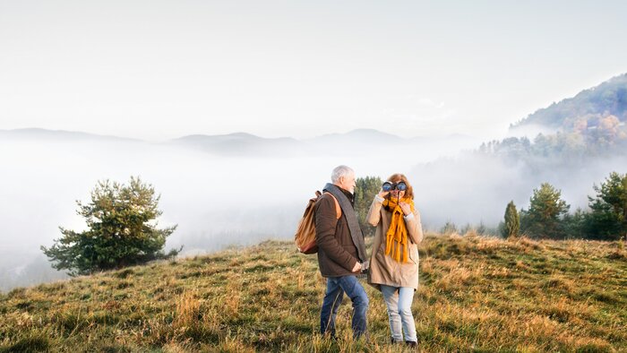 Seniorenpaar auf Spaziergang in einer Herbstlandschaft